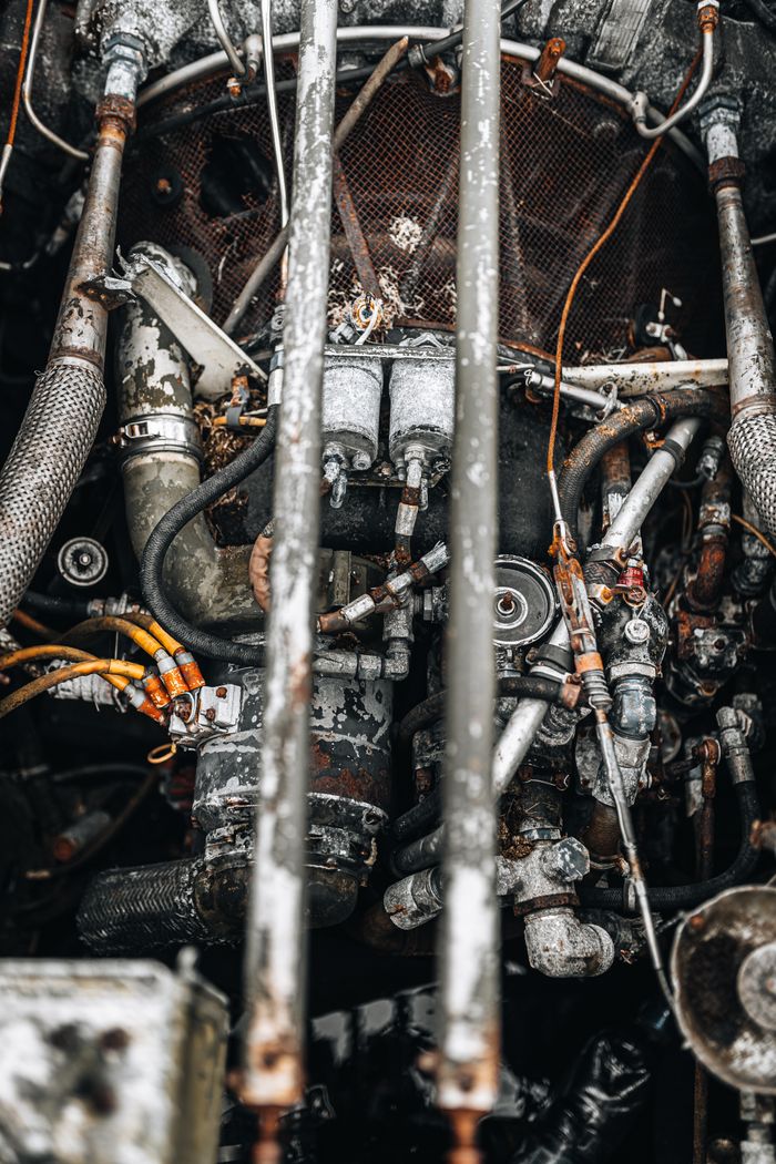 Rusty aircraft engine showing intricate details and pipes, conveying industrial degradation.